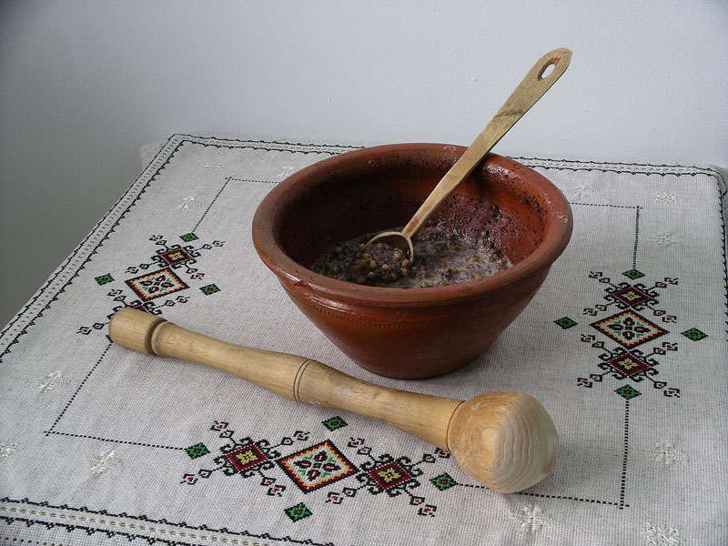 刺繍布の上の陶器に盛られたウクライナの冬の行事食クティアと木製の道具